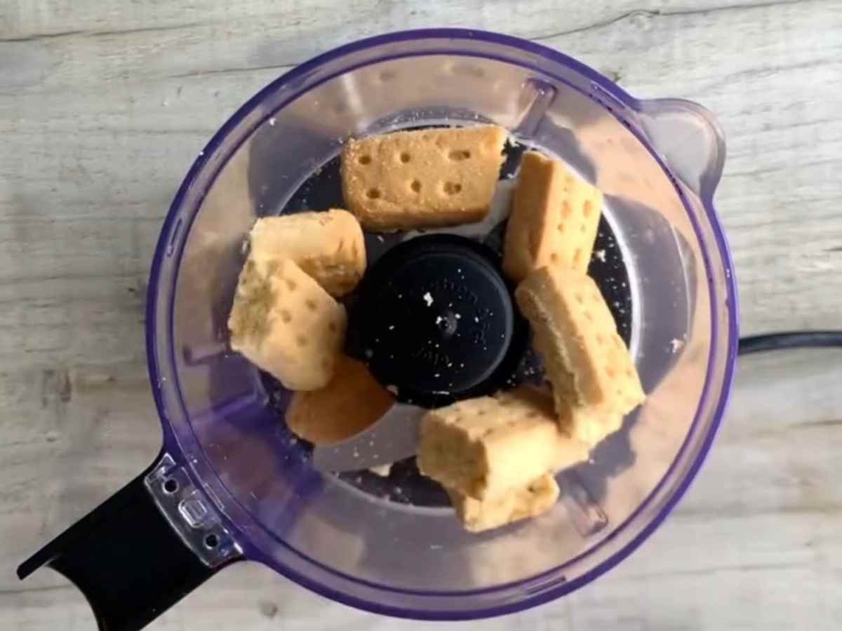 Cheesecake de Caramelo e Twix: A torta gelada que não vai ao forno e impressiona todo mundo! triturando bolacha amantegada