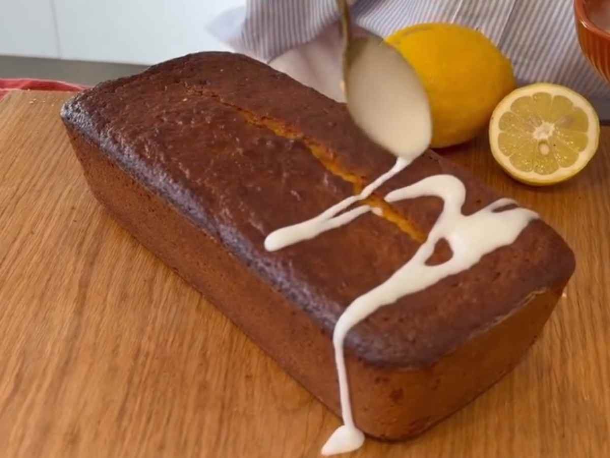 Passo 3 da Receita de Bolo de Limão - Glacê branco sendo derramado sobre a racha central do bolo úmido.