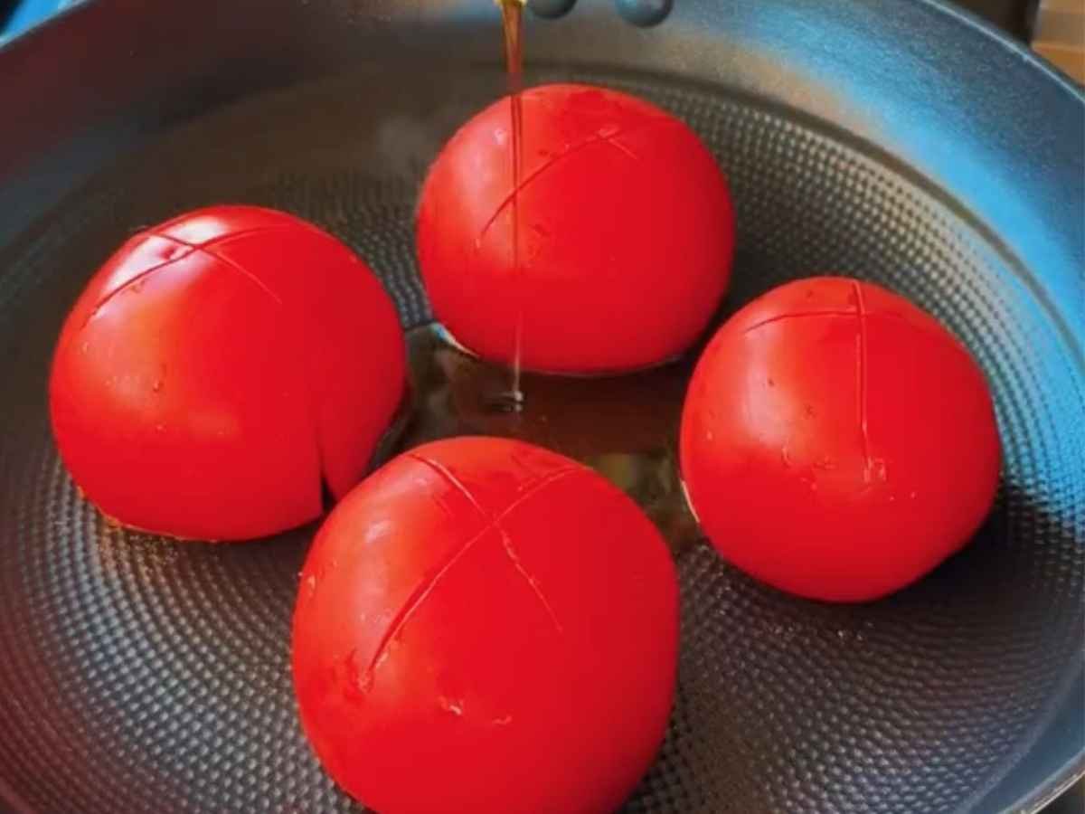 Passo 1 da Receita de macarrão ao molho Misto com batata Chips – Alho dourando no azeite com tomates frescos picados.