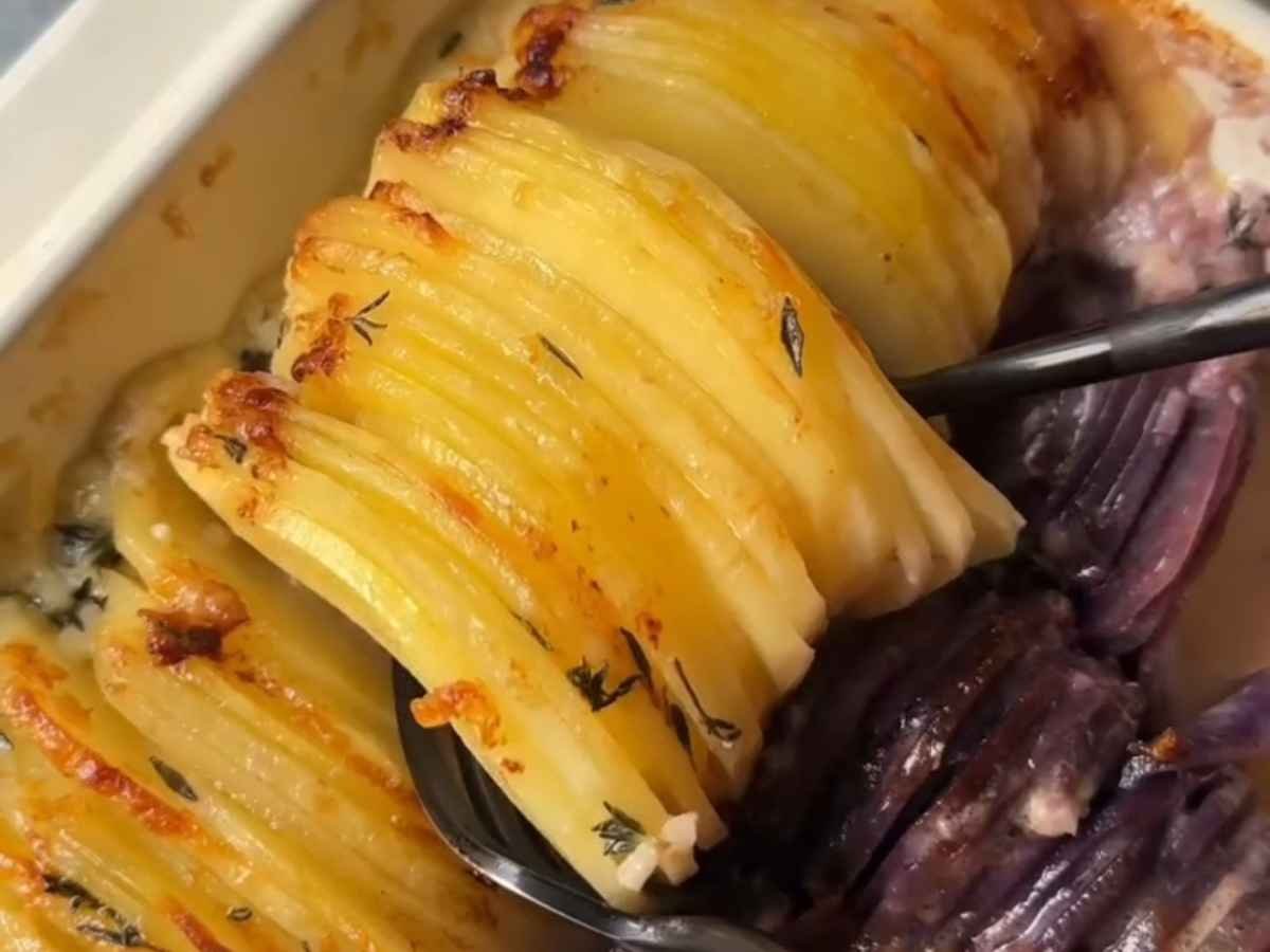 1. Passo 1 da Receita de Gratin de Legumes – Rodelas coloridas de batata sendo organizadas na travessa untada.